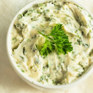 Close up image of garlic chive butter topped with parsley.