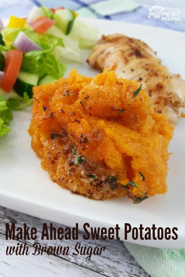 Close up of mashed brown sugar sweet potatoes on a plate with salad and chicken.