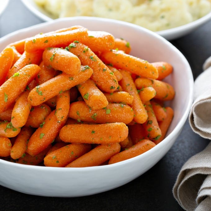Close up of Honey Glazed Carrots in a white serving bowl.