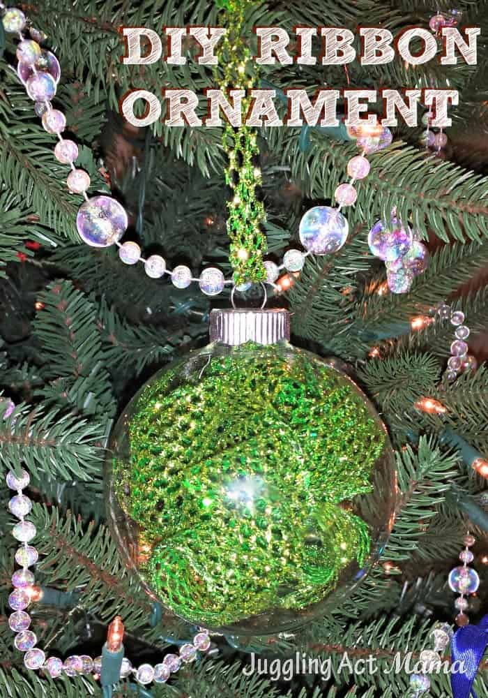 Clear ornament filled with ribbon on a Christmas tree.
