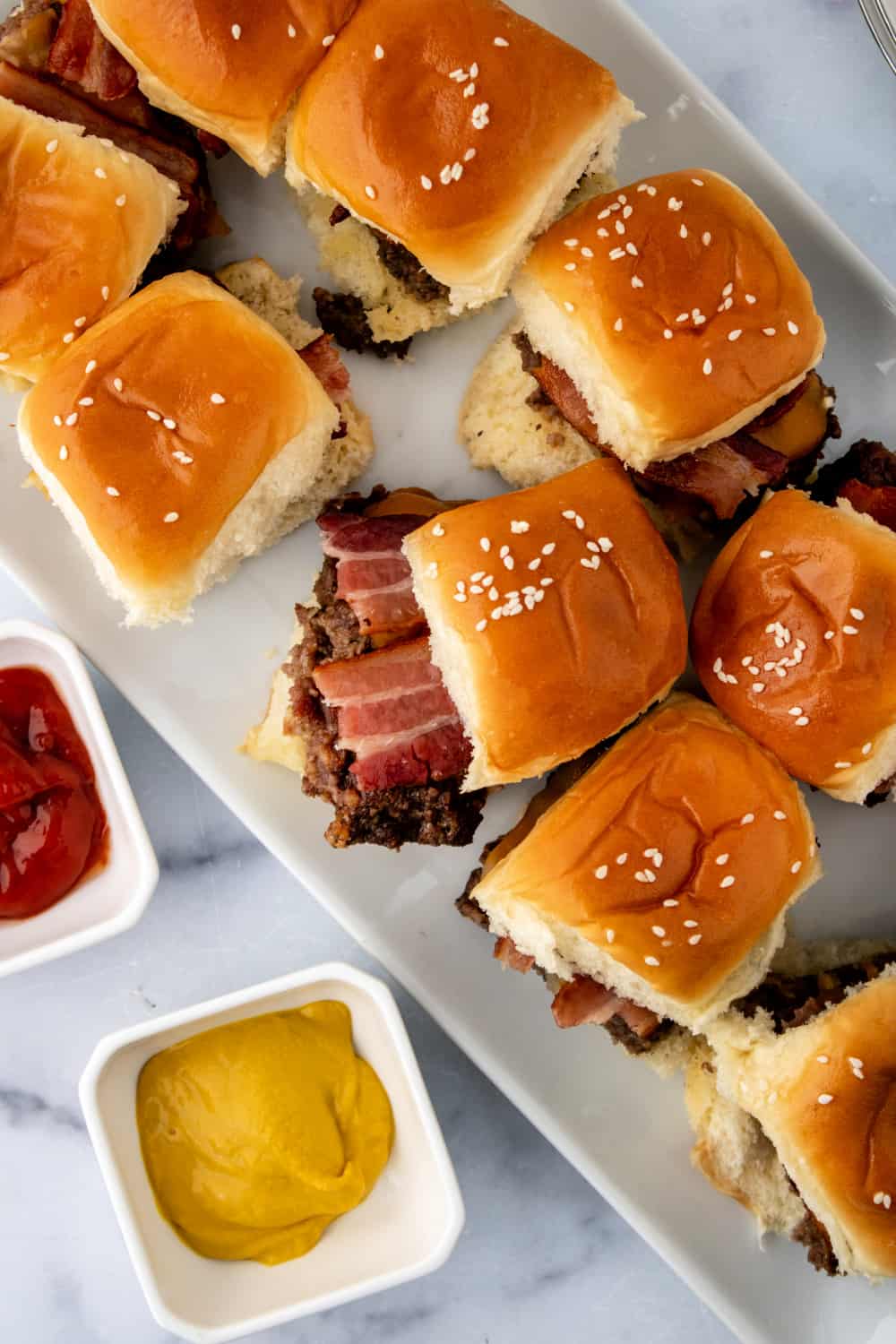 Be the hit of your next potluck with these delicious Bacon Cheeseburger Sliders. They are so easy to make and so flavorful. via @jugglingactmama