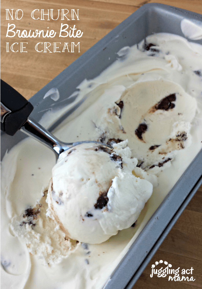 No Churn Vanilla Ice Cream with brownie bites in a long pan with an ice cream scoop balling up a scoop.
