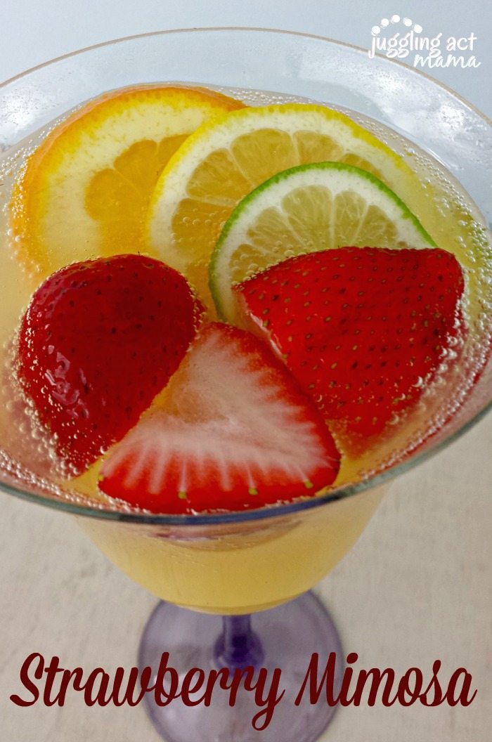 Close up of Strawberry Mimosa garnished with fresh strawberries and oranges.