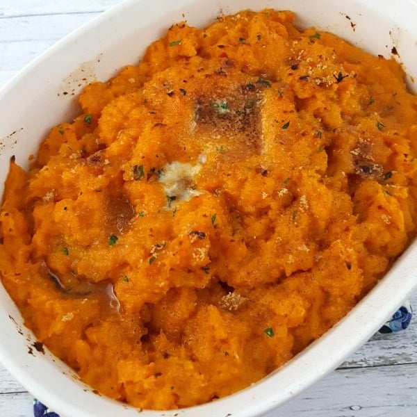 Top down image of sweet potatoes in a white casserole dish.