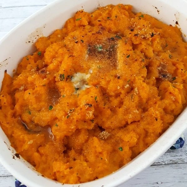 Top down image of sweet potatoes in a white casserole dish.
