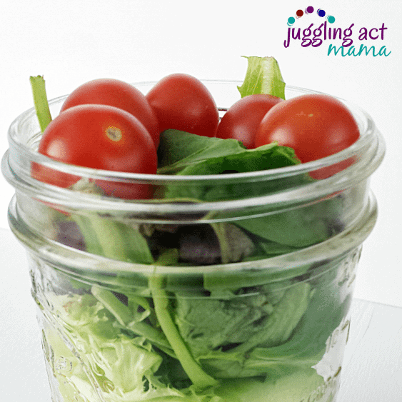 Close up image of a salad layered in a mason jar.