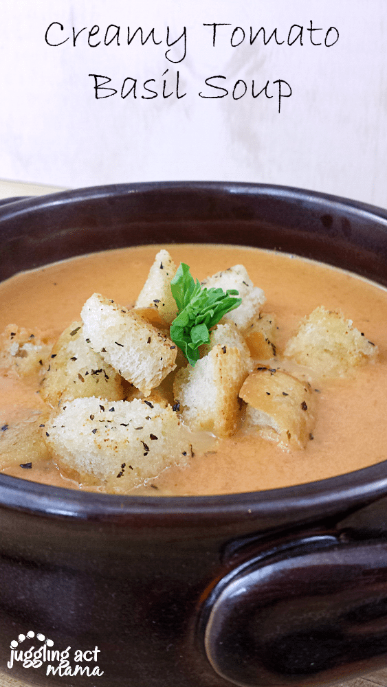 This Creamy Tomato Basil Soup topped with homemade Garlic Basil Croutons is comfort food at its finest. It comes together quickly and is perfect for cold winter weeknights. via @jugglingactmama