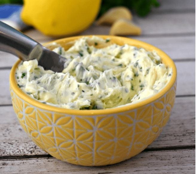 close up of garlic and herb compound butter in a yellow dish