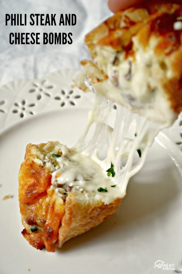 Close up image of a steak and cheese bomb roll being pulled apart to expose ribbons of cheese.