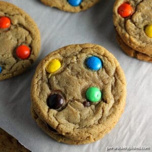Close up image of brown sugar m and m cookies on parchment paper.