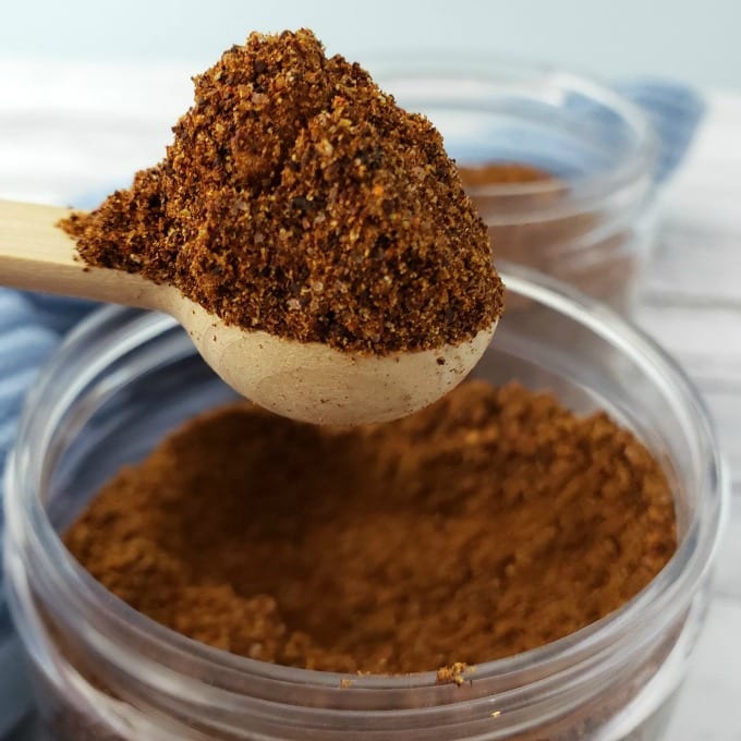 Cowboy Spice Mix in a wooden spoon over a glass jar.