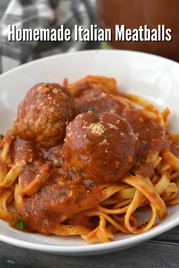 Authentic Italian Meatballs topping a bowl of spaghetti with sauce.