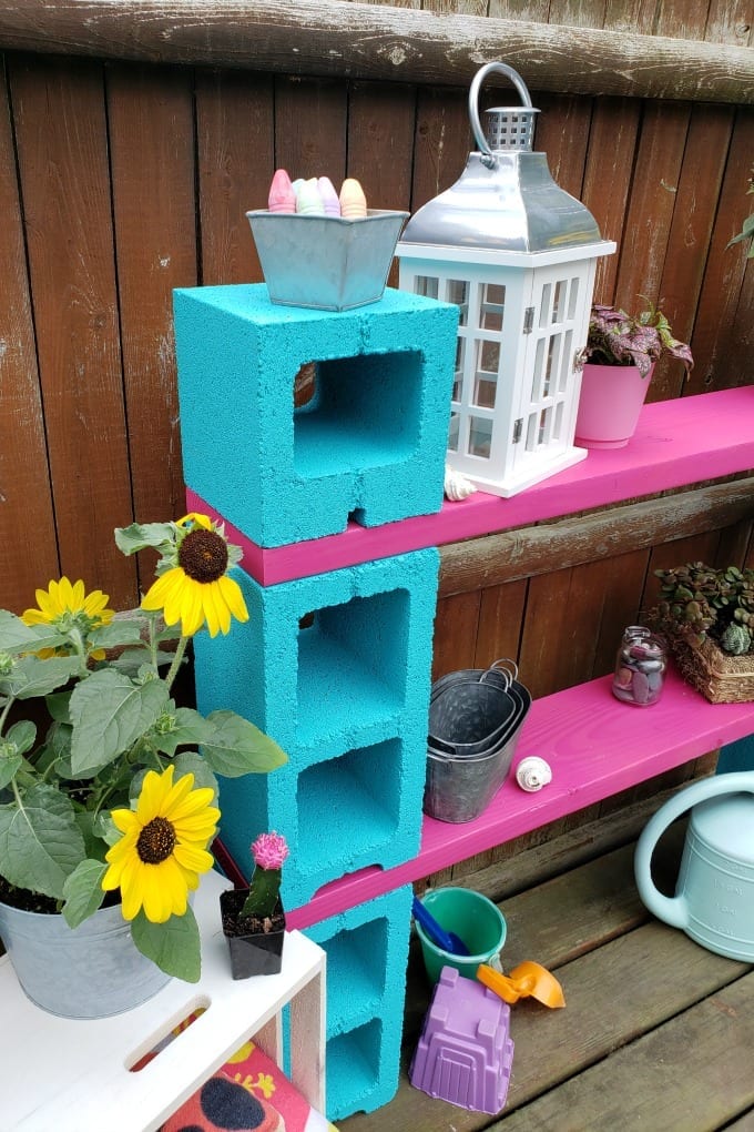 DIY Outdoor Storage doesn't have to be expensive! These Cinder Block Shelves are simple and economical. Add color and functionality to your patio or backyard in no time! via @jugglingactmama
