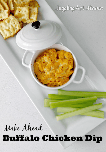 Bubbly hot Buffalo Chicken Dip in white bowl served with crackers and celery.
