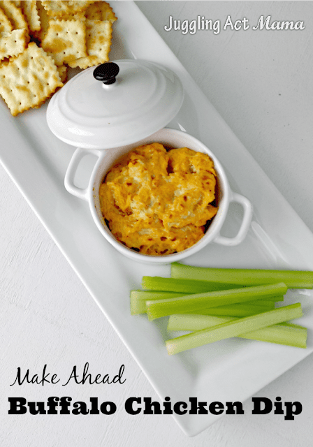 Bubbly hot Buffalo Chicken Dip in white  bowl served with crackers and celery.