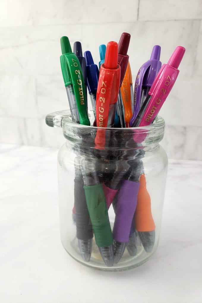 Classroom Supplies for Teachers: multi colored pens in a small clear jar on a marble counter 