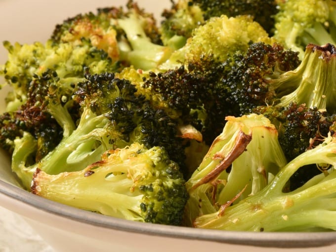 Bowl of roasted broccoli on a table