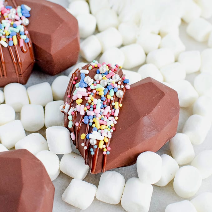 DIY Hot Chocolate Bombs surrounded by mini marshmallows.