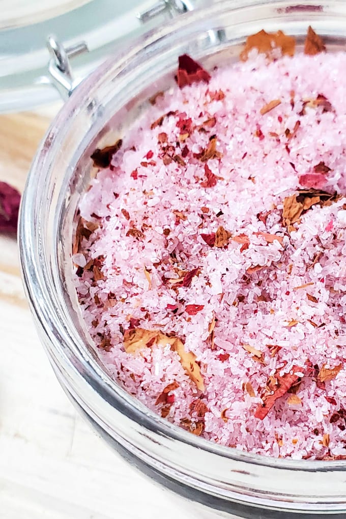 Close up, top down view of rose bath salts in a glass jar.
