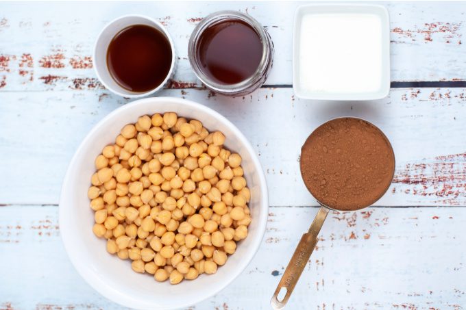 Ingredients to make chocolate hummus - chickpeas, cocoa powder, milk, vanilla and honey.