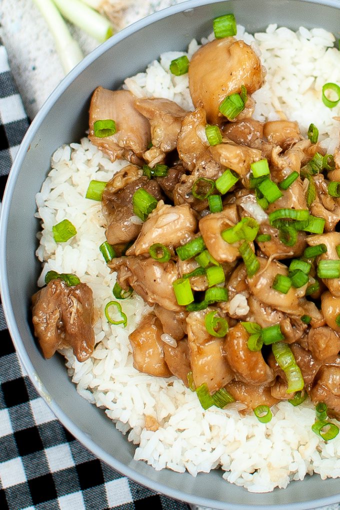 Close up view of Instant Pot Bourbon Chicken topped with green onions on a bed of rice.