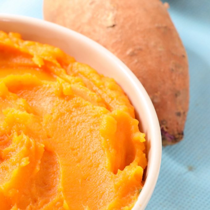 Close up of sweet potato puree in a white bowl.