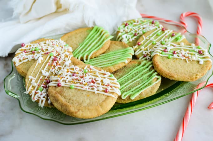 Pile of Christmas cookies on a green plate.