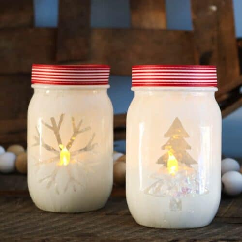 Close up image of two Christmas votive holders made from mason jars.