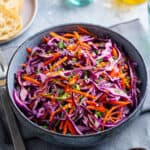 close up of Asian Purple Cabbage Slaw in a dark bowl