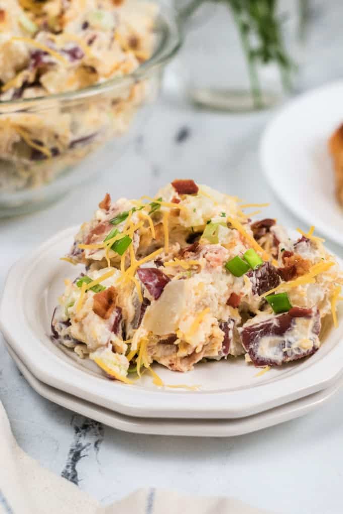 Sides To Go With Pulled Pork: Loaded potato salad on a white plate.