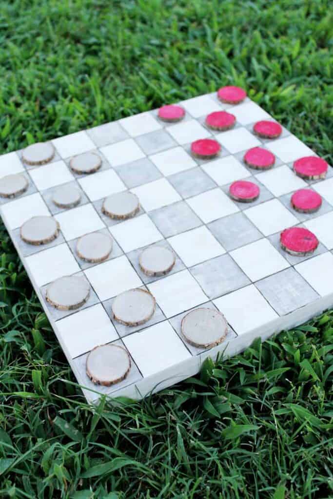 Outdoor checkers game in the grass.