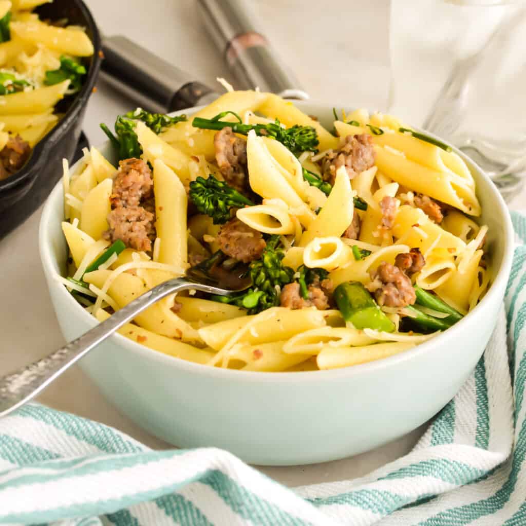 Close up of Pasta with Sausage and Broccolini in a bowl with a fork.