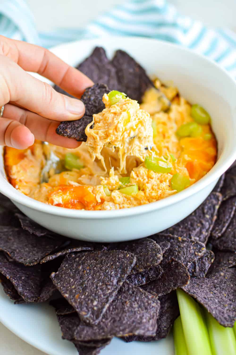 Easy Buffalo Chicken Dip Recipe is so simple to make! Loaded with blue cheese, Frank's Red Hot Sauce and baked in the oven until hot and bubbly! You can used canned chicken or rotissiere. This dip is one of our most popular recipes of all time. It's a simple game day staple and you can even make it ahead! #chickendip #buffalodip #jugglingactmama #tailgatingfood via @jugglingactmama