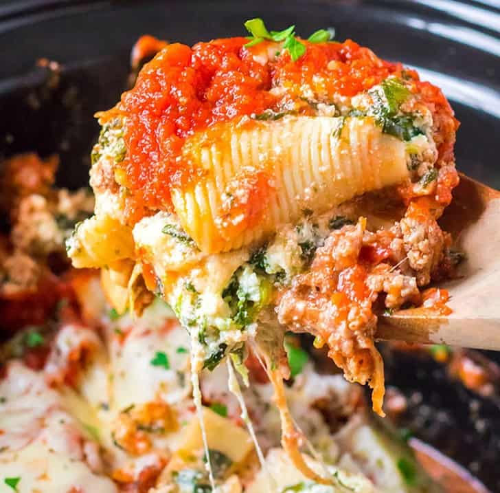 Close up of a spoonful of Slow Cooker Stuffed Shells with Sausage and Spinach.