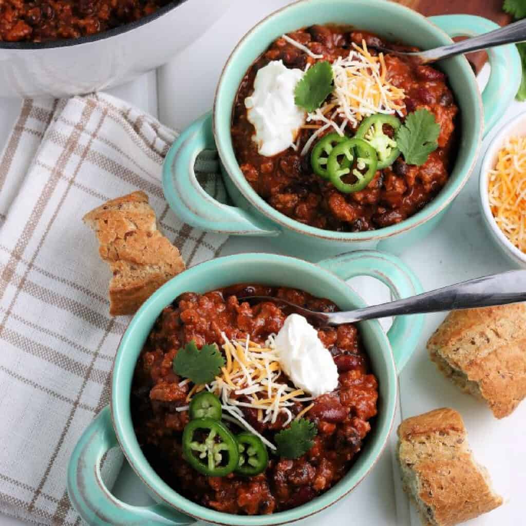 Top down view of Leftover Turkey Chili in bowls with spoons.