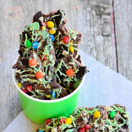 Close-up of Mint Bark with M and M candies, gold sprinkles and green frosting.