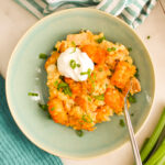 Bowl of Buffalo chicken tater tot casserole with sour cream on top.