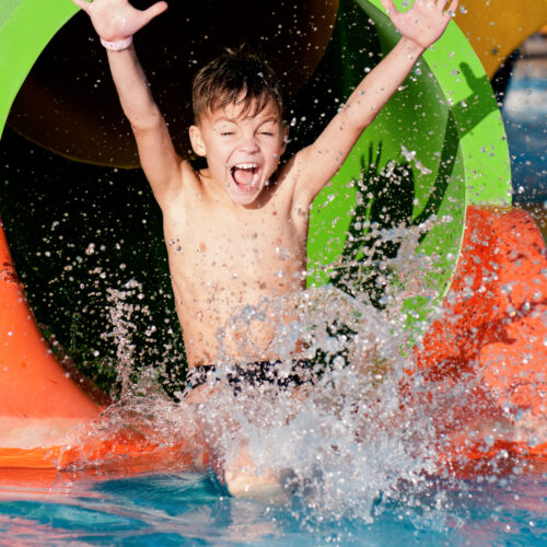 Boy going down a water slide at a water park.