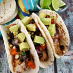 Chicken Tacos with avocado, corn, and tomatoes.