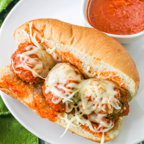 Slow Cooker Meatball Subs with cheese on a plate.