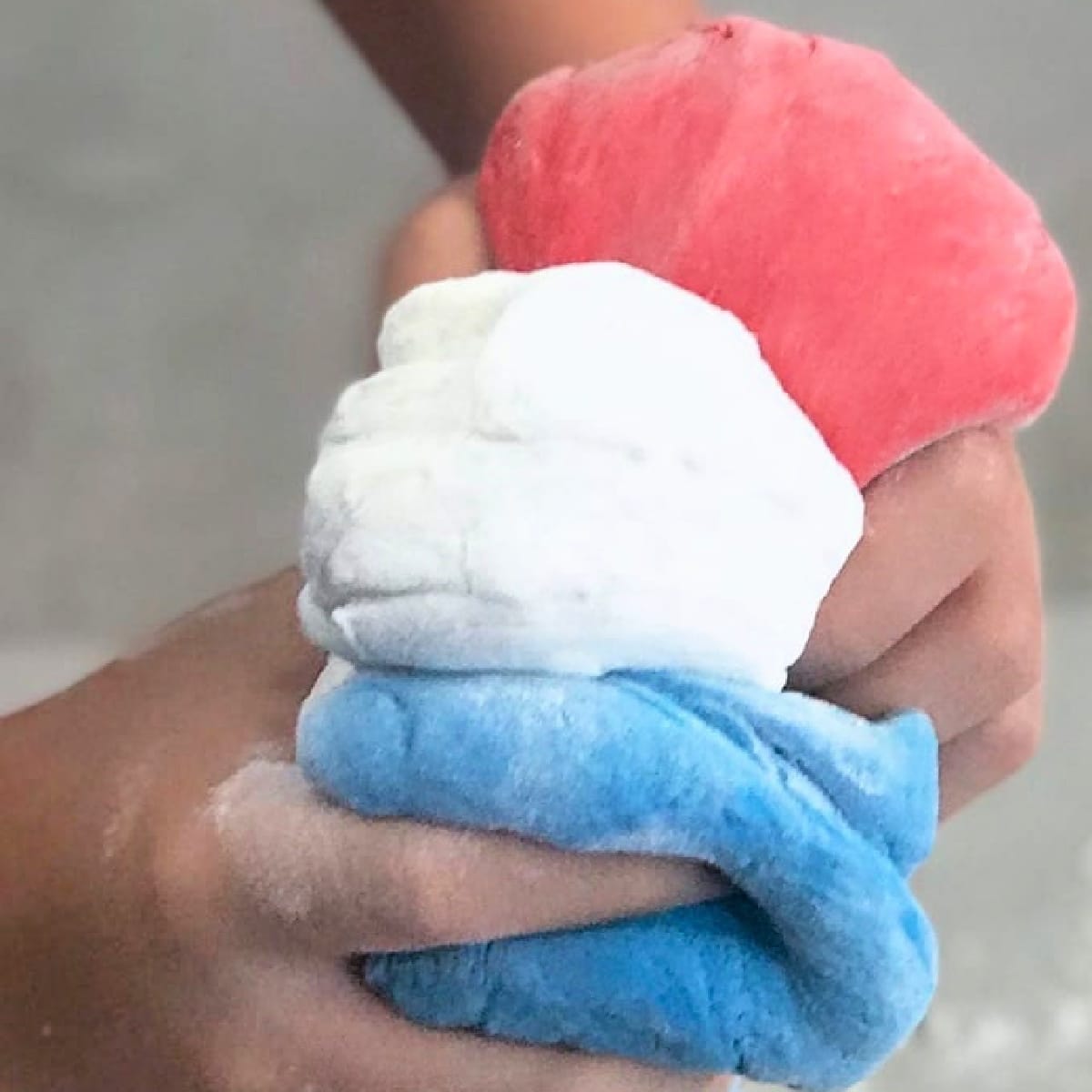 Child holding Fluffy Slime in three different colors.
