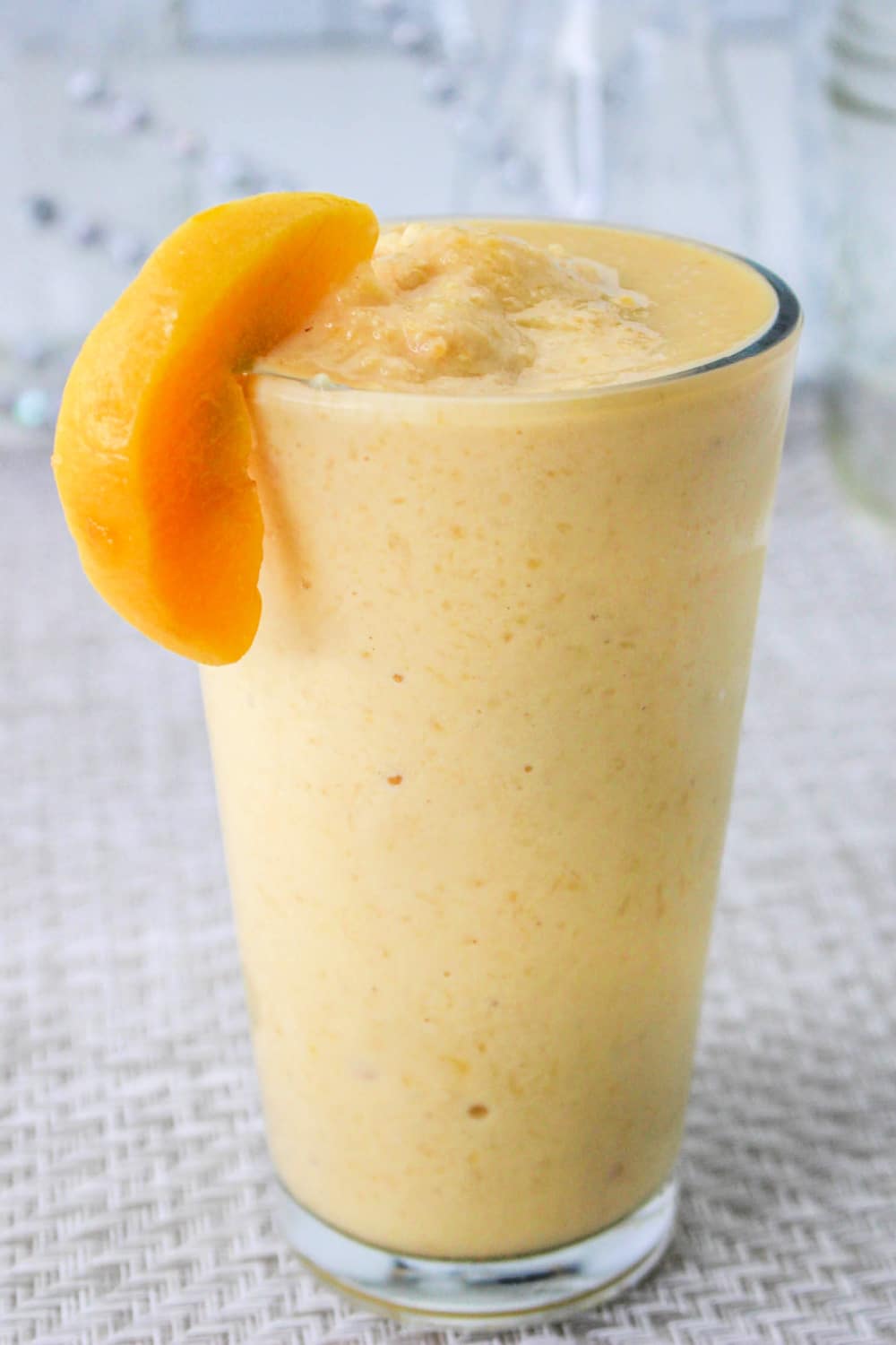 An Orange Peach Smoothie made with fresh peaches and orange juice are the perfect breakfast, healthy snack, or even a sweet treat instead of ice cream. via @jugglingactmama