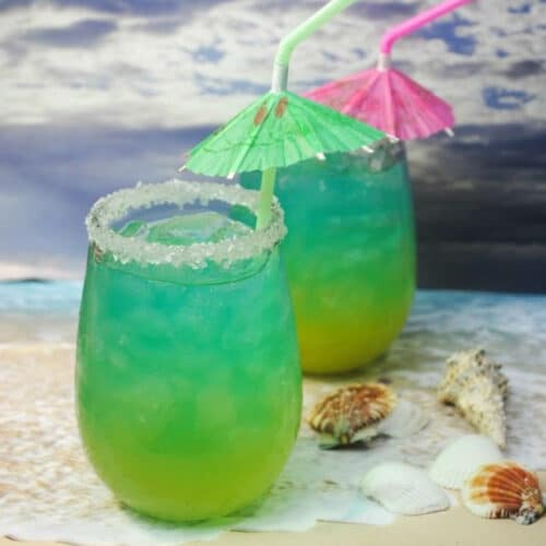 Two glasses of Tropical Storm Punch with straws and drink umbrellas.