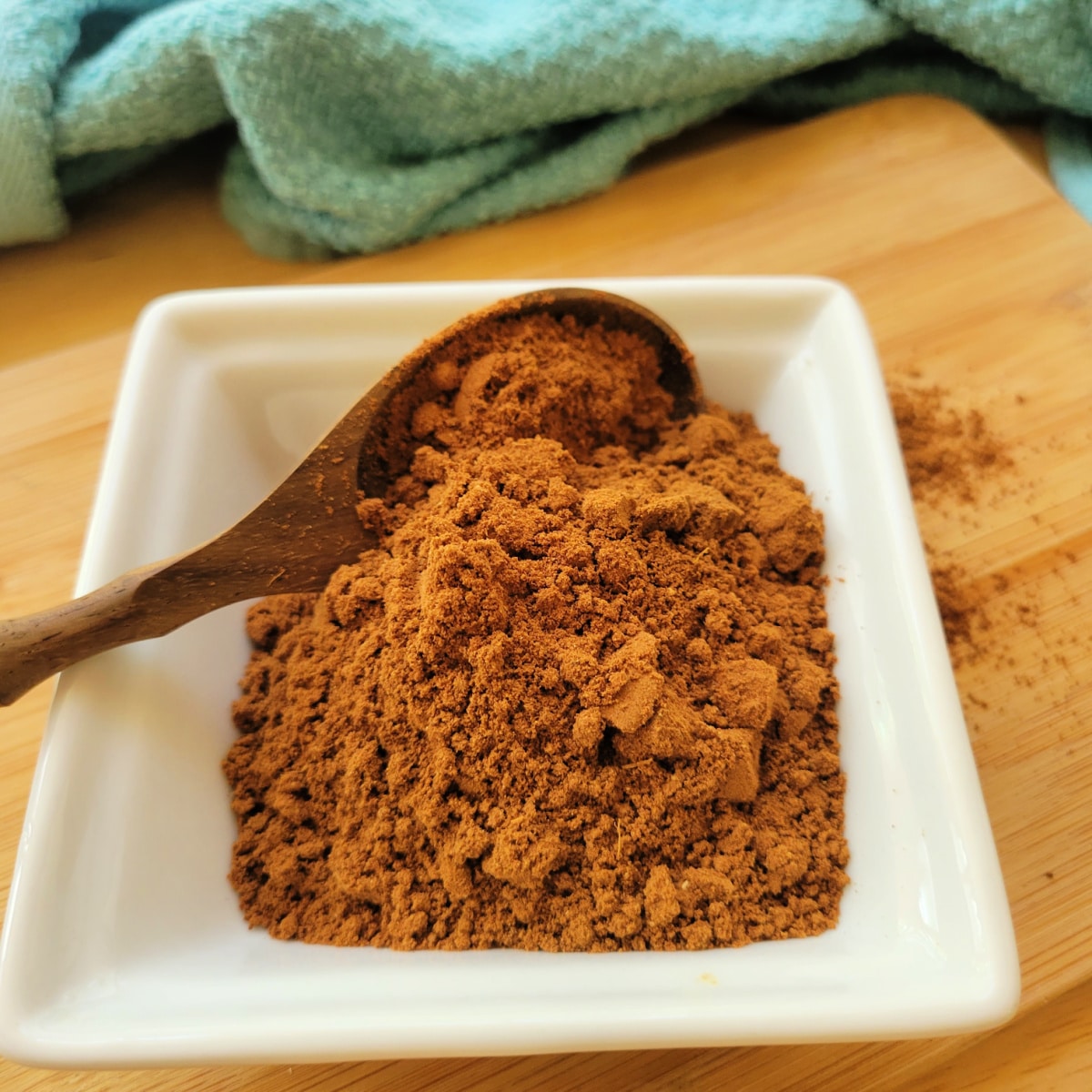 Apple pie spice in a small bowl with a wooden spoon.