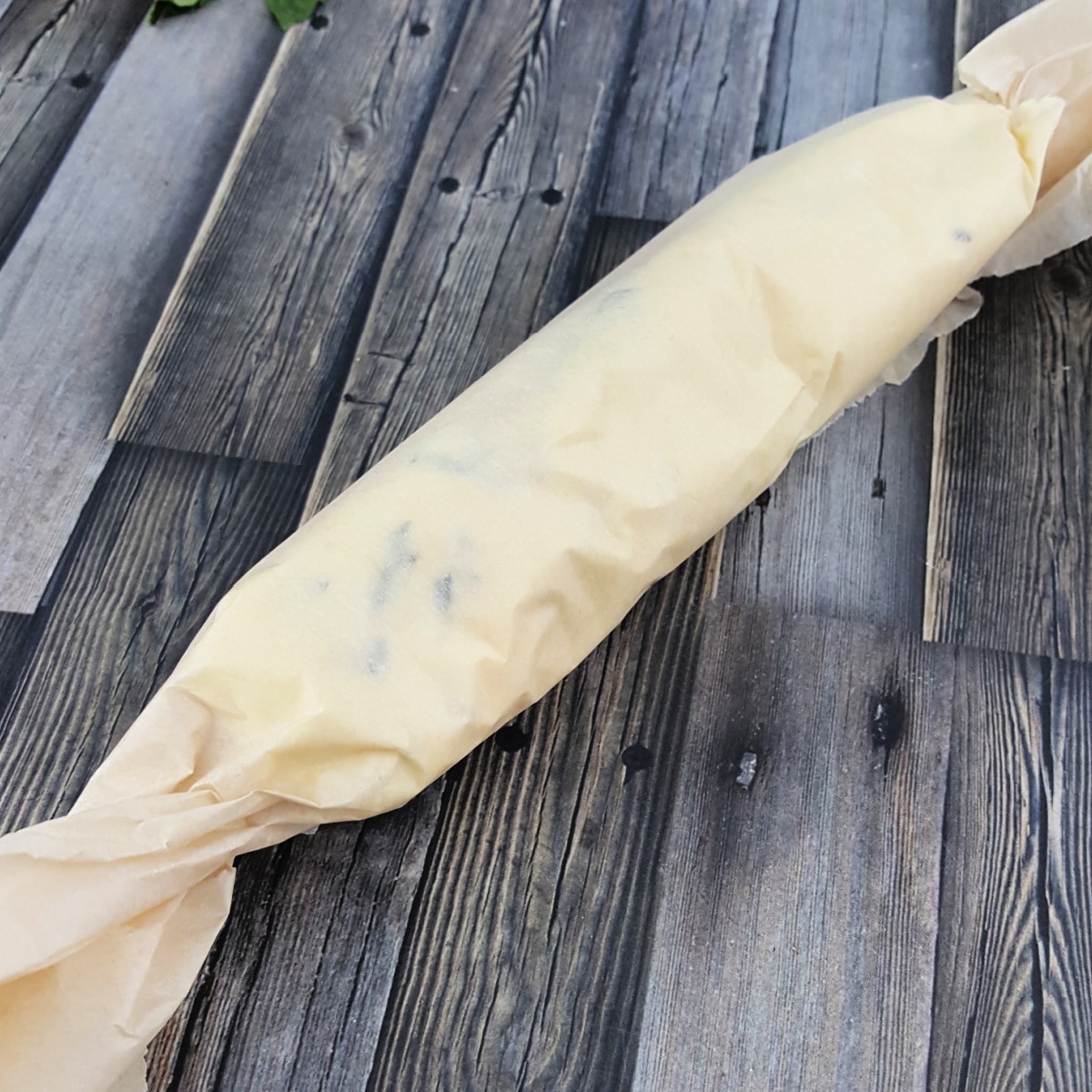 Rolled garlic butter in parchment paper.