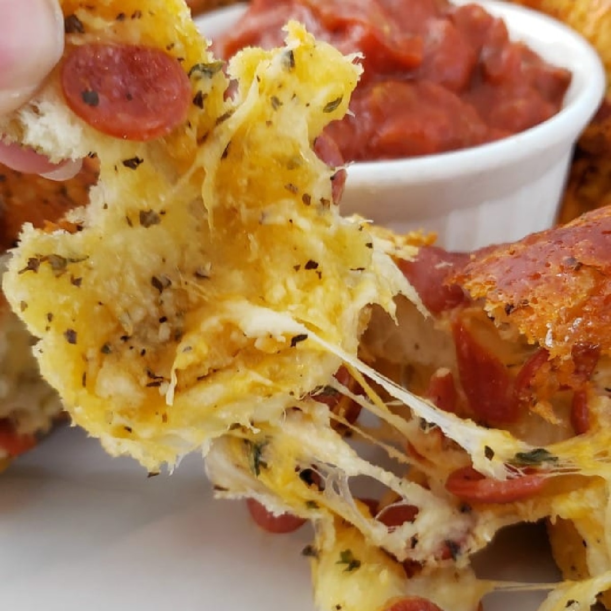 Fingers pulling Easy Pull Apart Pizza Bread.
