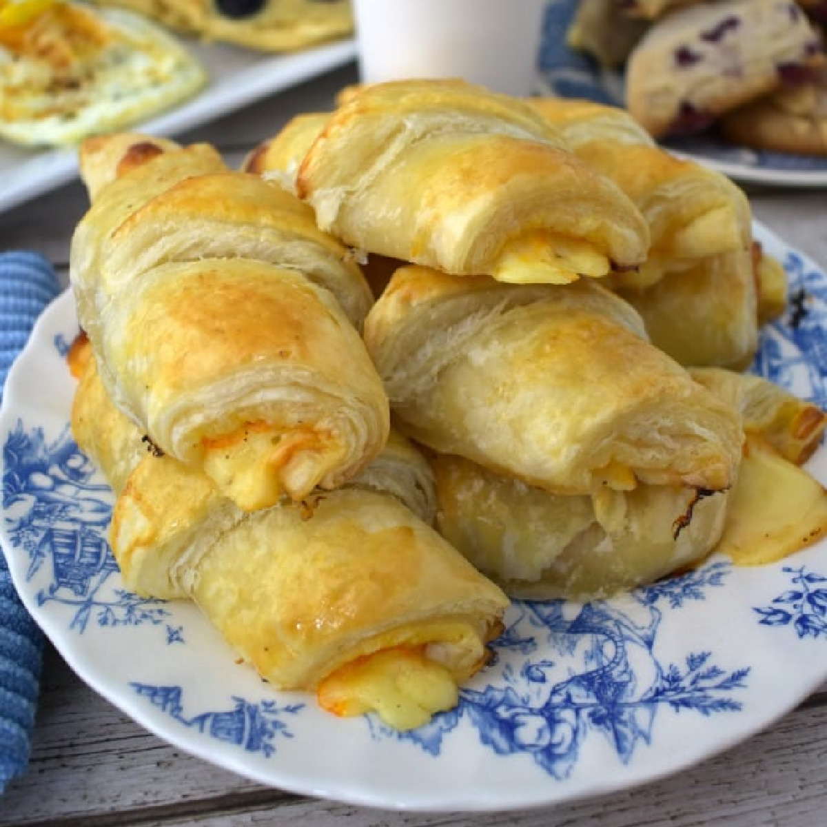 Ham and Cheese Croissants piled onto a blue and white plate.