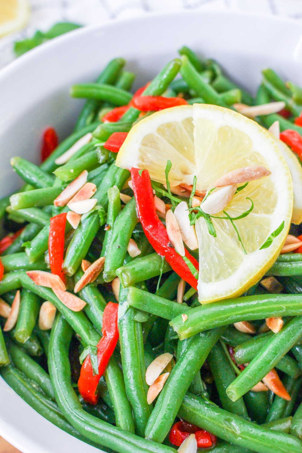 Italian Green Bean Salad with almonds in a bowl garnished with lemon.