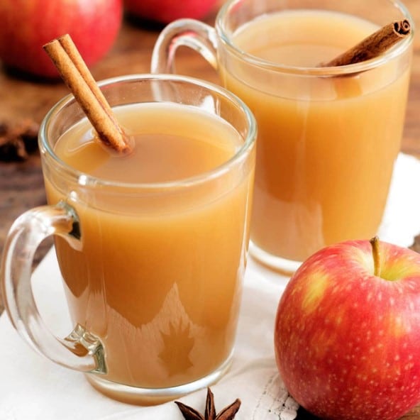 apple cider in cups with cinnamon sticks.