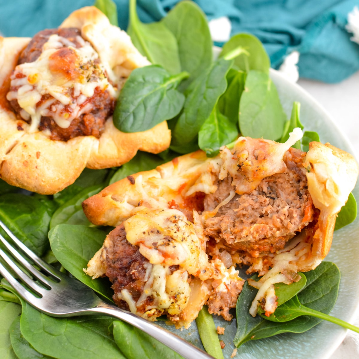 Cheesy Meatball Sub Cubcakes on a bed of greens.